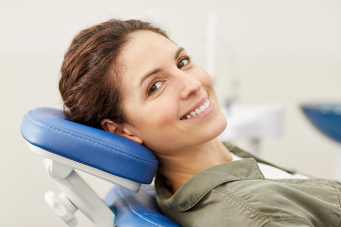 Mujer que conoce los alimentos prohibidos después de una limpieza dental.