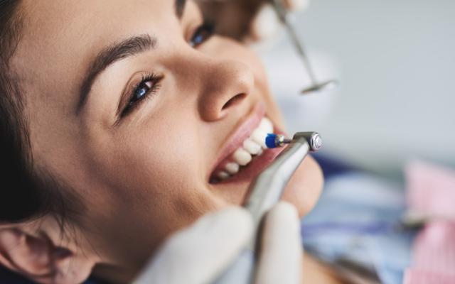 Mujer haciéndose una limpieza dental.